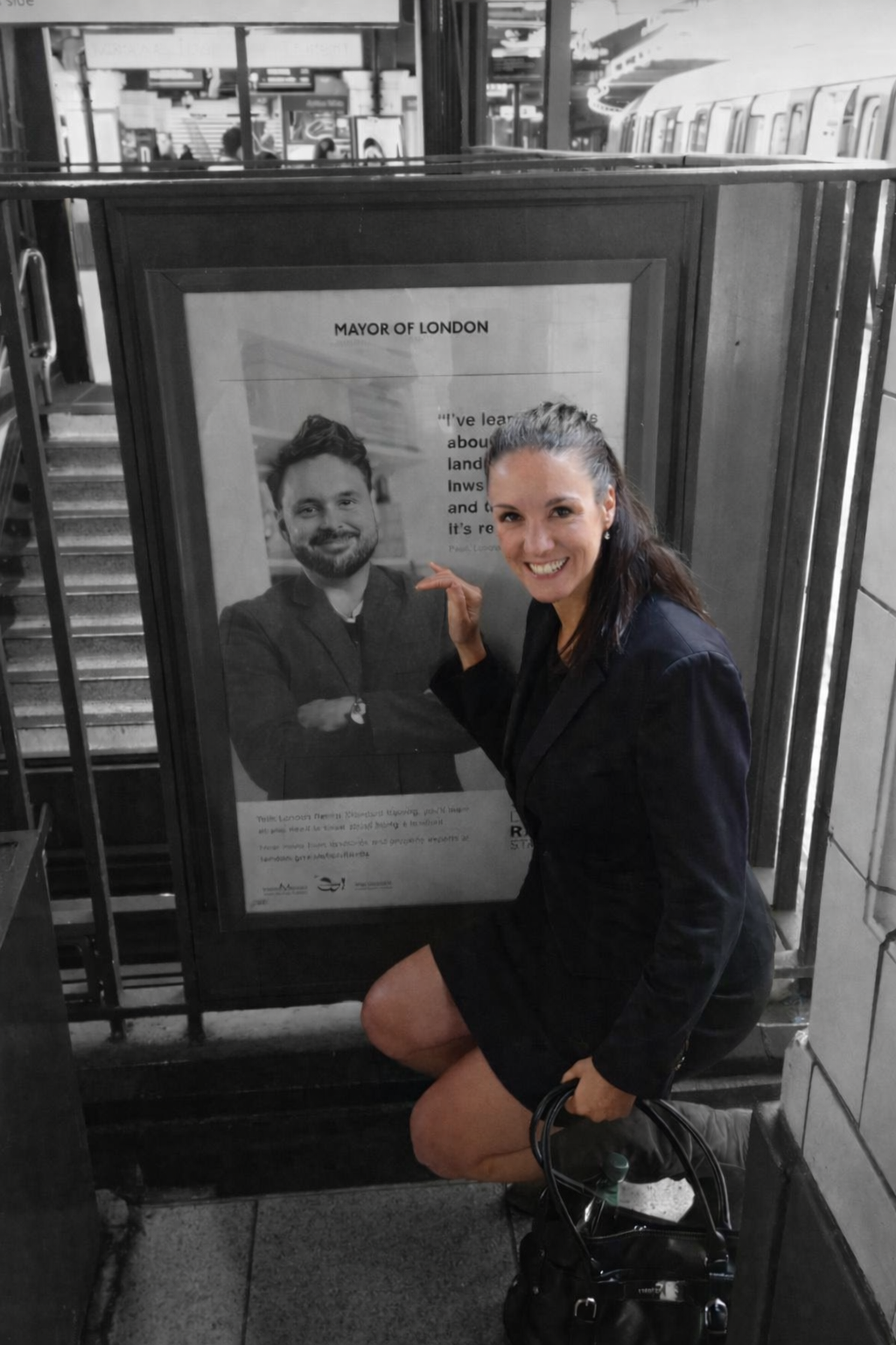 Faye pointing at a poster in a London station