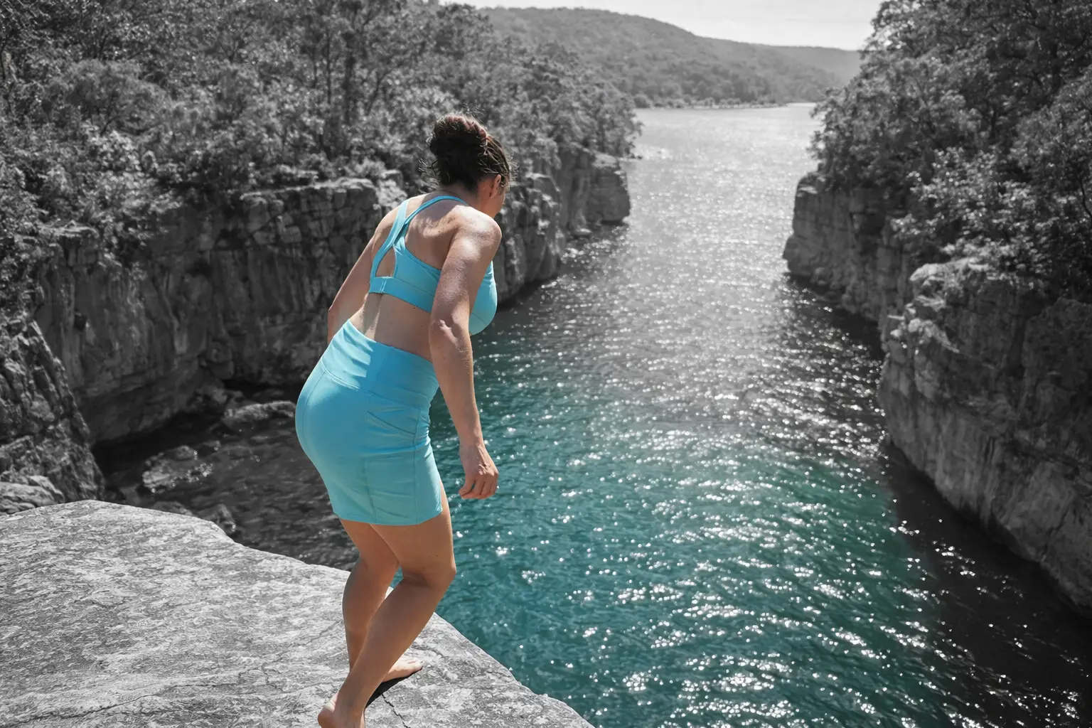 Faye standing on a rock ledge above a river gorge
